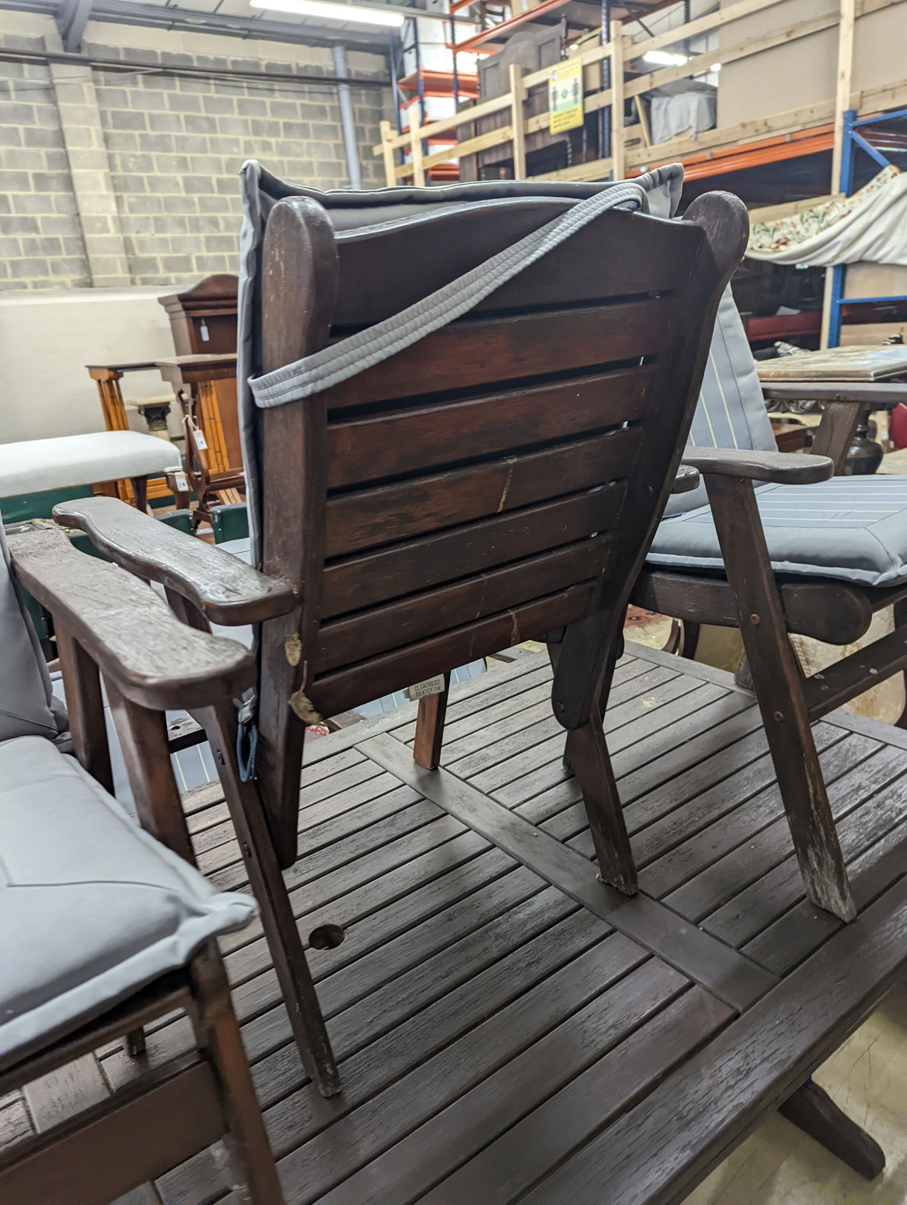 A Fechters stained teak rectangular garden table, length 220cm, depth 107cm, height 72cm and eight elbow chairs and seat pads
